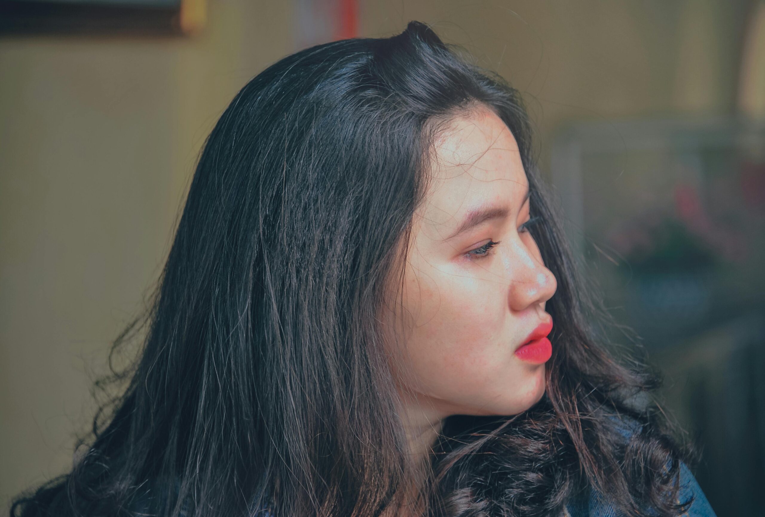 Profile photo of a young woman with red lipstick, showcasing natural beauty.